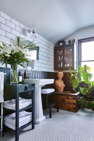Jason Traves house: Bathroom with black panelling halfway up the wall with white metro tiles on the upper half