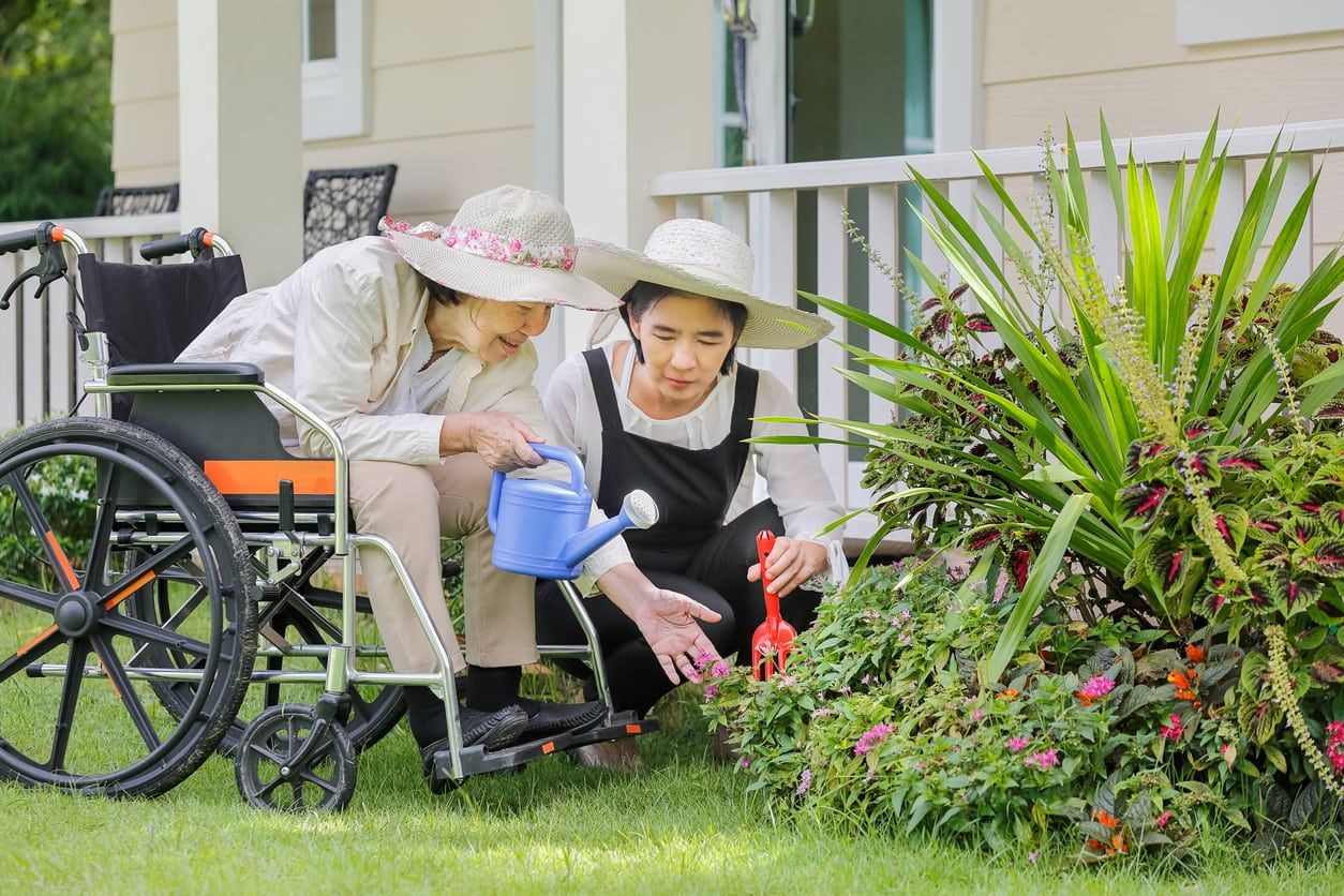 Gardeners Watering Plants In Front Yard