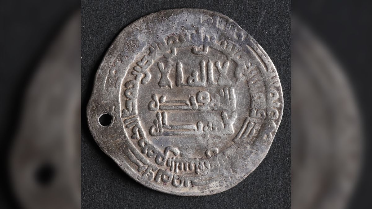 A silver coin with Arabic writing on it.