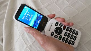 Bedste mobiler til seniorer: En person, der holder en hvid Doro 6880 med åben skærm.