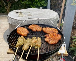 Weber Smokey Joe cooking small pieces of meat including skewers