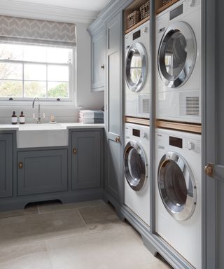 A blue mudroom laundry area with four electrical appliances and butler's sink