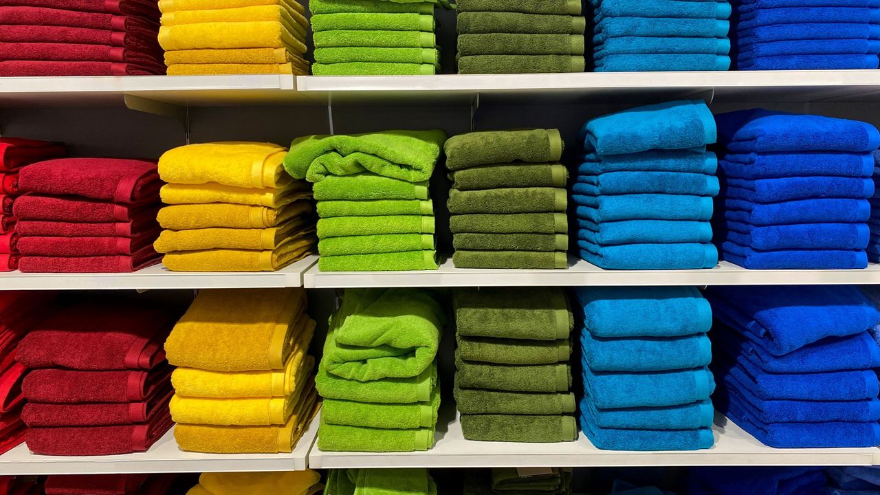 A stack of towels for sales in rainbow order.