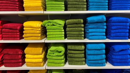 A stack of towels for sales in rainbow order.