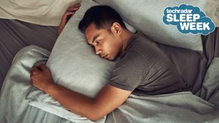 Man laying awake in bed clutching his pillow