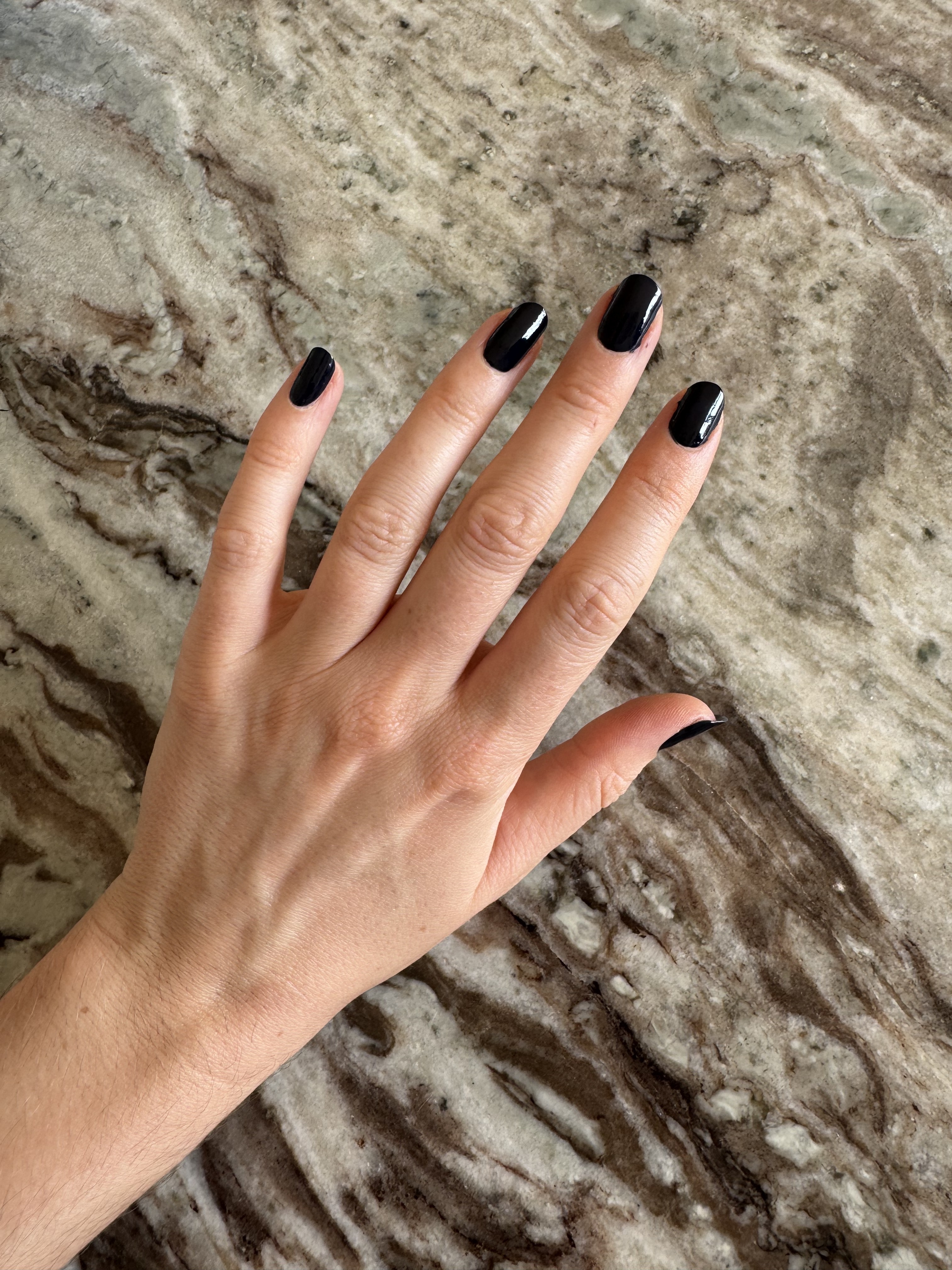 Beauty editor Eleanor's hand painted with Essie gel couture caviar bar nail polish, an inky navy shade