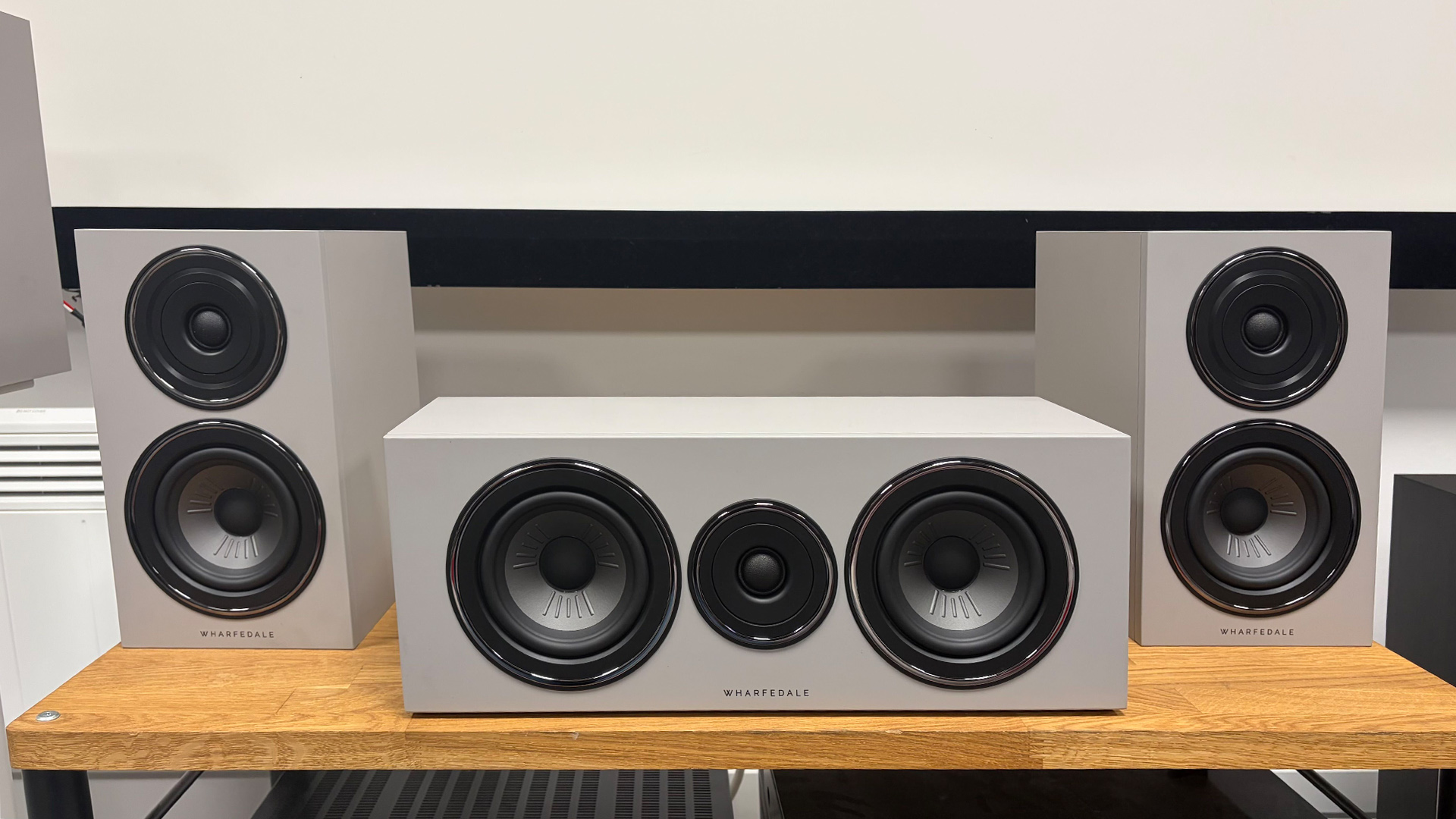 Wharfedale Diamond 12.1i HCP speaker package, two surrounds flanking centre speaker on wooden AV rack