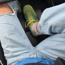 Fashion person smythsisters wears a trending trainer brand 2026. She wears green Dries Van Noten trainers. She wears them with blue ripped denim jeans, a blue tee and grey jumper. This image was recently taken from her Instagram. 