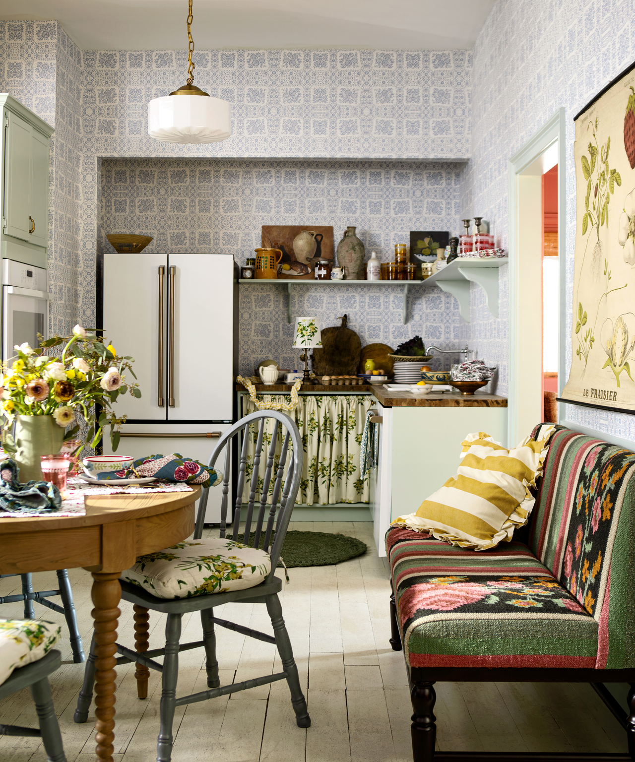a cozy cottage kitchen with a banquette bench, a kitchen table, and a small counterspace with open shelf cabinets above