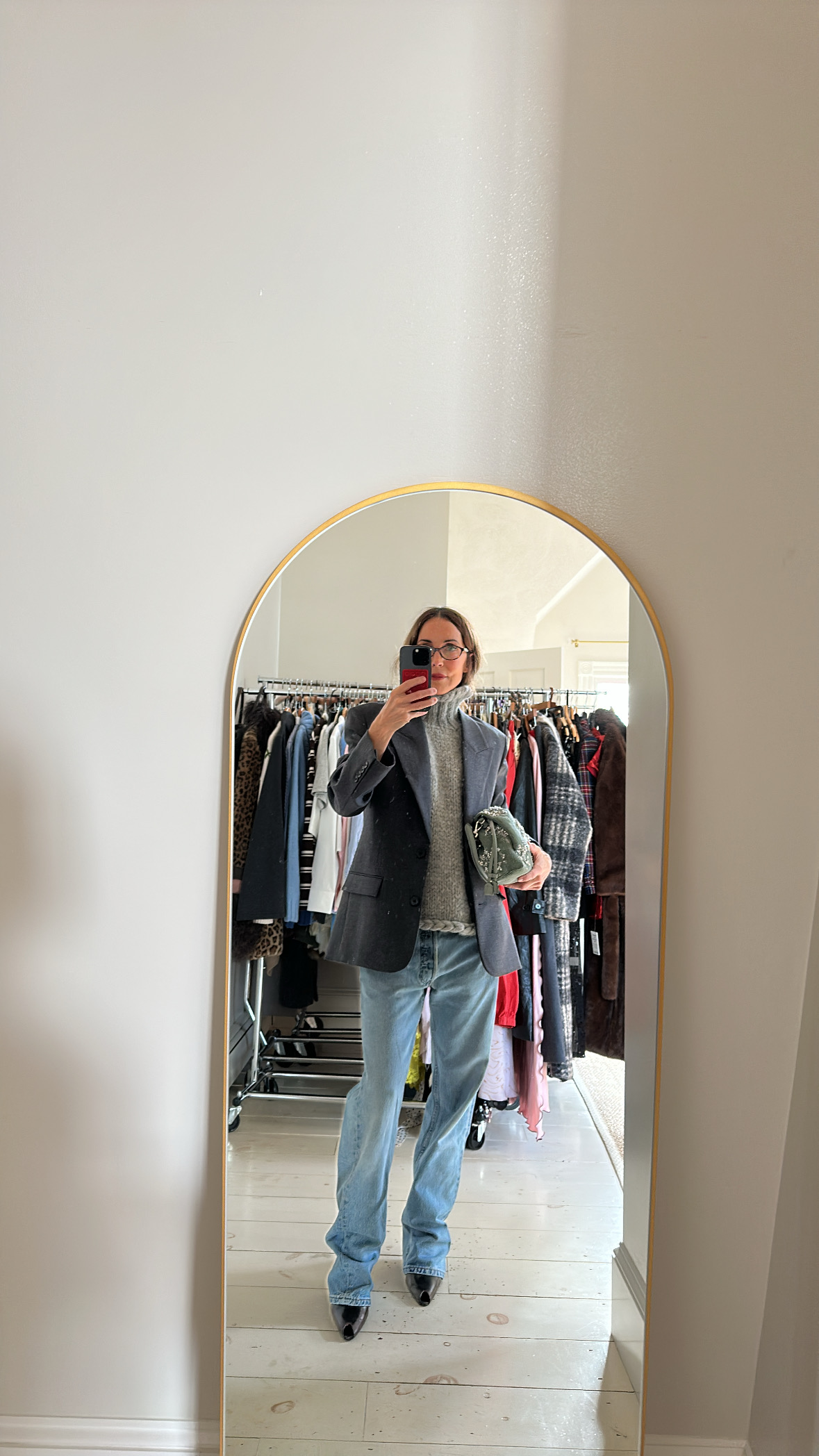 Larissa Mills wearing blue jeans, a gray sweater, and nacy blazer