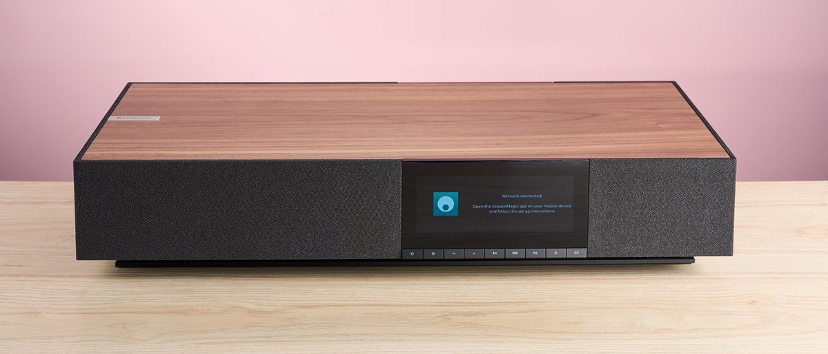 The Cambridge Audio Evo One on a worktop in front of a pink background.