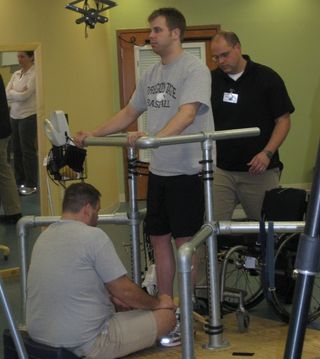 An experimental spinal cord therapy allowed Rob Summers, 25, a paraplegic, to stand on his own for the first time in four years.