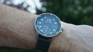 En grön och svart Withings ScanWatch Horizon sitter runt en persons handled