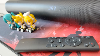A close up of the Creative Stage Pro and the soundbar's remote.