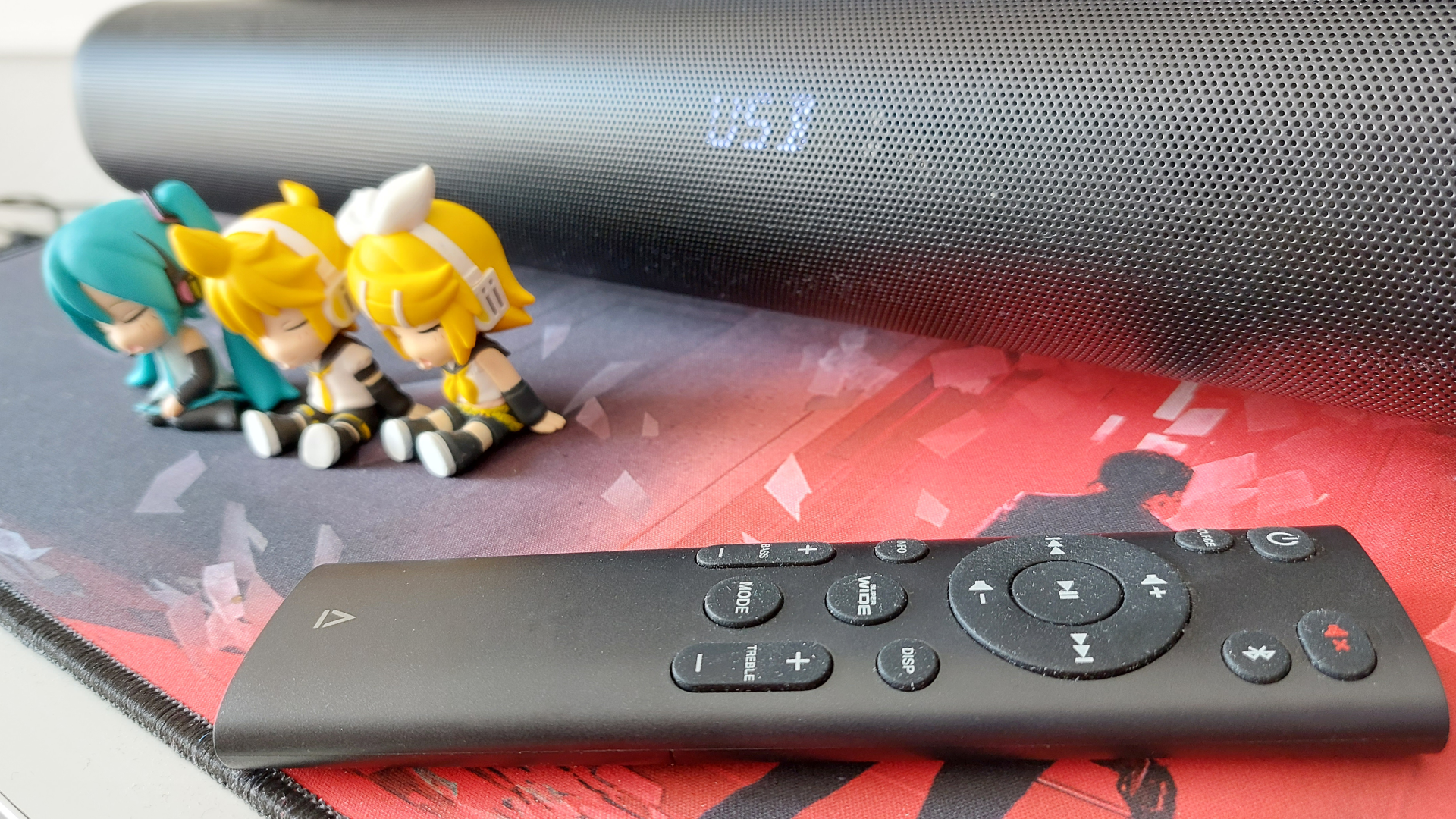 A close up of the Creative Stage Pro and the soundbar&#039;s remote.