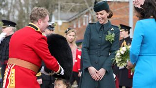 Kate middleton laughing at a little girl wearing a beefeater hat