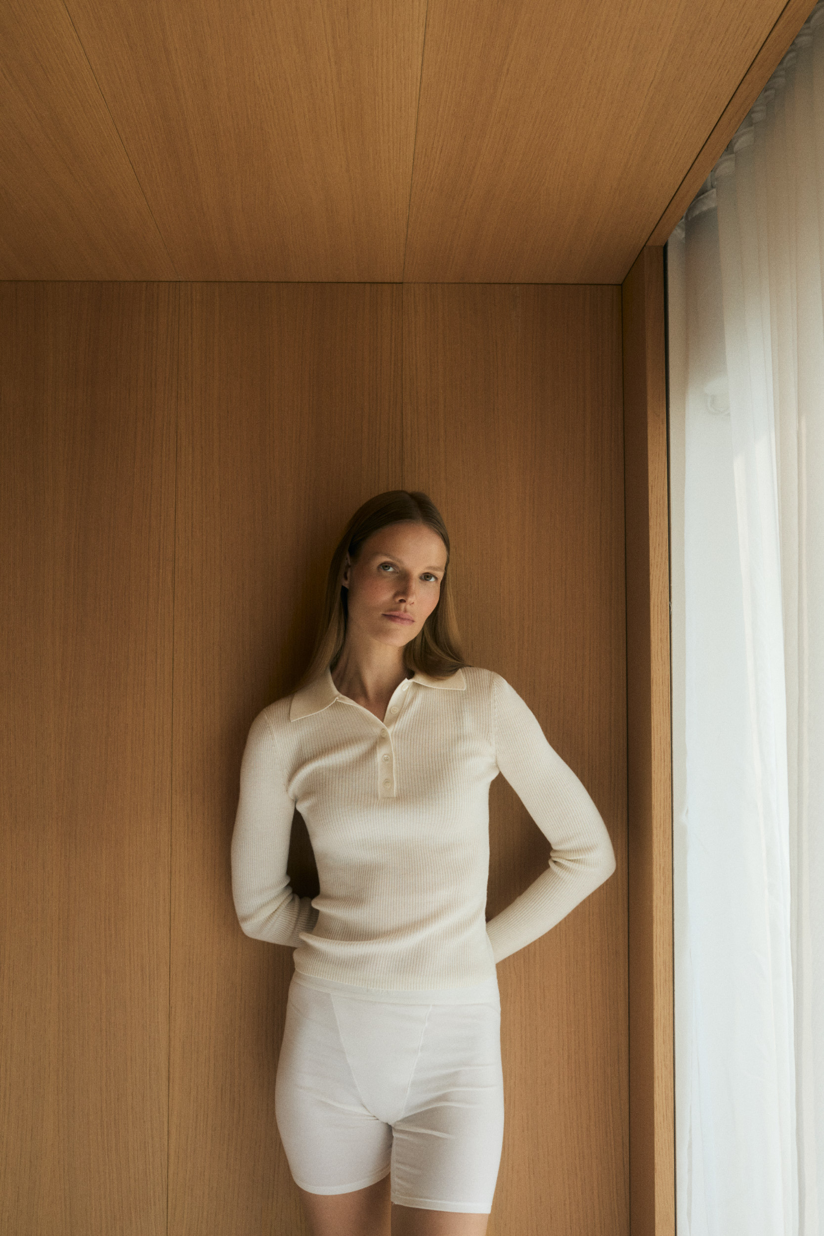 An image of a white long-sleeve polo neck shirt from Almada Label