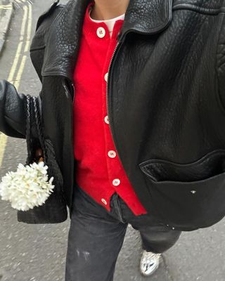 @lucywilliams02 wearing a red cardigan and black jeans