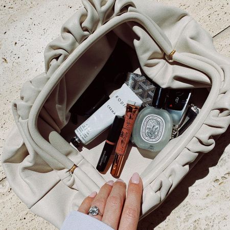 A handbag with a Diptyque perfume inside