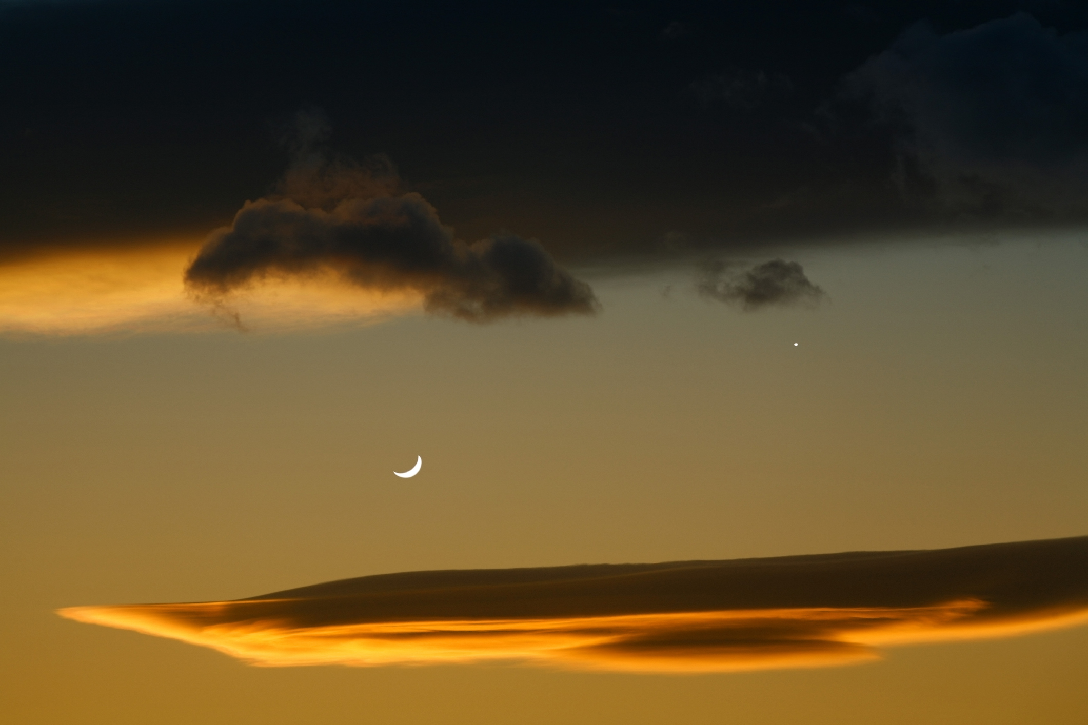 thin crescent moon and venus shining to the right.