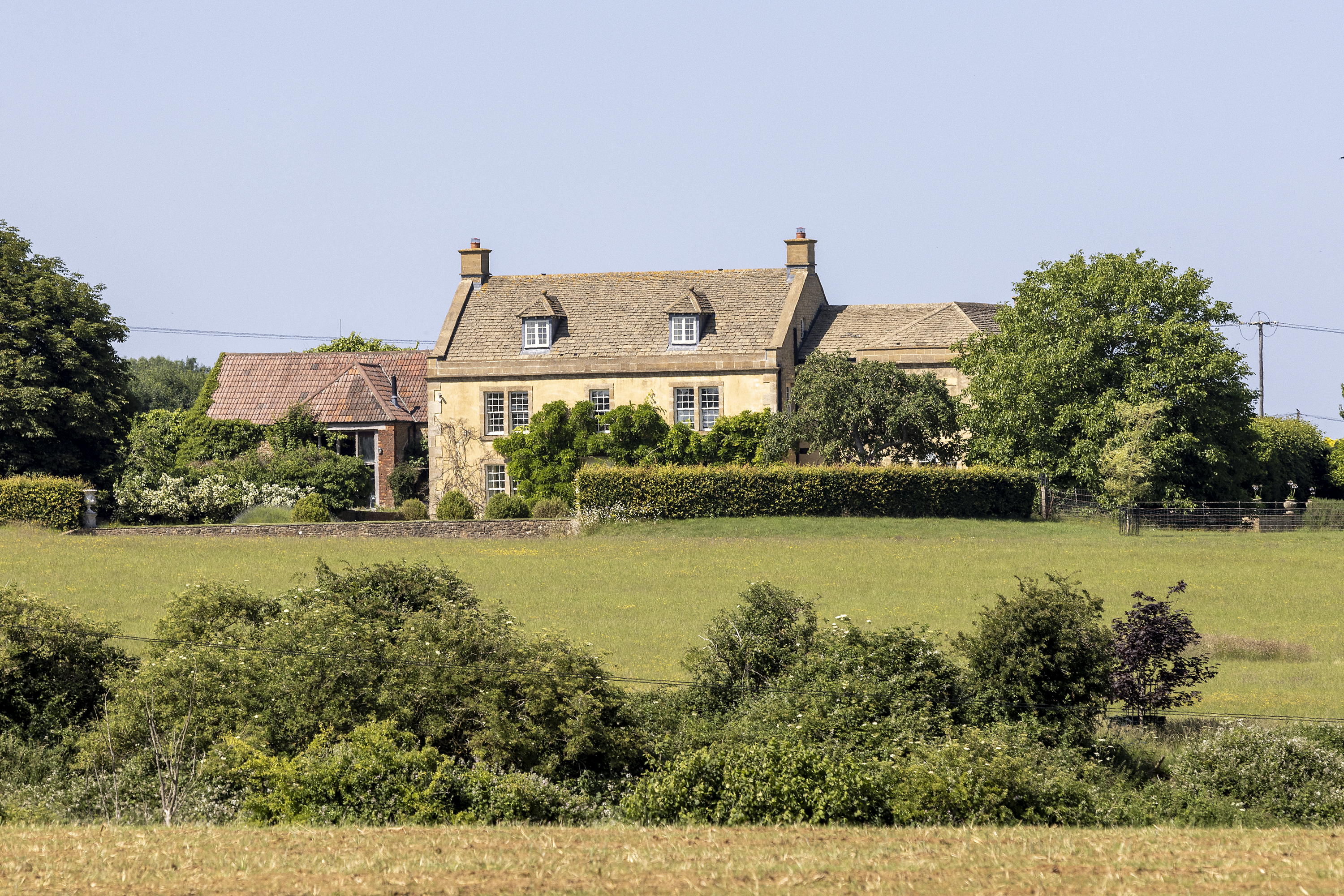 Mount Farm from the outside surrounded by bushes and grass