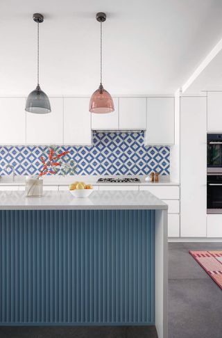 a white kitchen with a blue patterned splashback