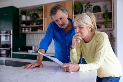 Mature couple reading bad news in a letter in the mail - domestic life concepts