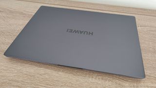 Huawei Matebook D 16 review: grey laptop closed on a table by a white wall