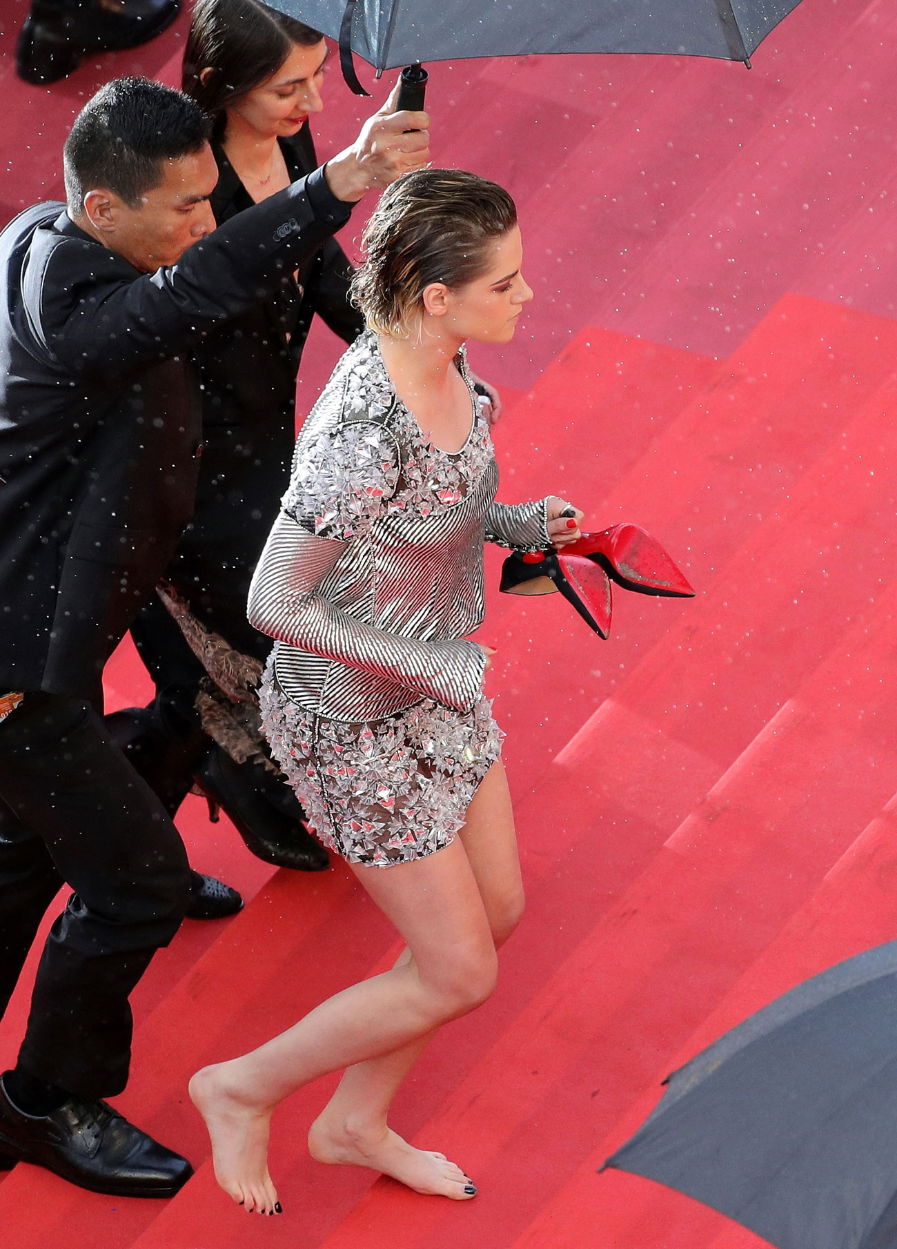 Kristen Stewart went barefoot on the red carpet wearing a silver short dress.