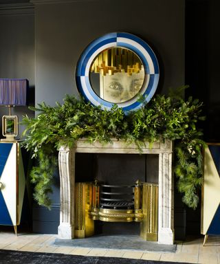 A Christmas fireplace decorated with a fresh green foliage garland