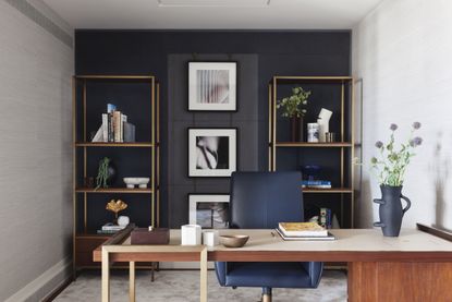 tidy desk in home office with blue walls and art
