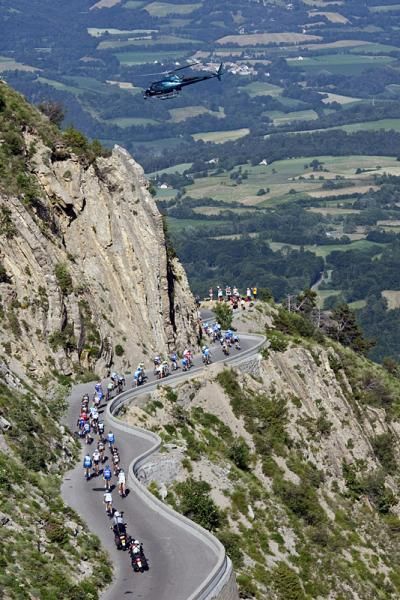 A helicopter hovers over the peloton on its descent of the Col du Noyer.