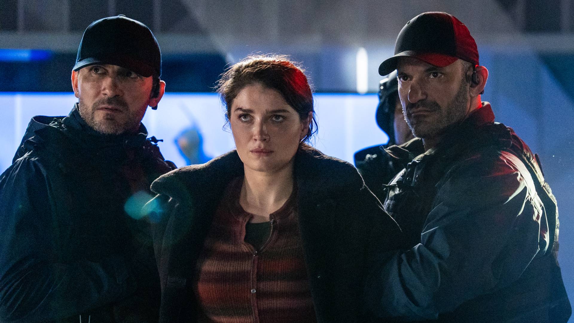 Eve Hewson as Jane, being restrained by two men in Disclosure Day