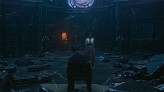 Image from the Marvel T.V. show Loki, season 2 episode 3. Image from the Marvel T.V. show Loki, season 2 episode 3. A woman and an orange cartoon clock stand before a man slumped over in a throne. The dark castle room they are in has debris everywhere and looks very gloomy.