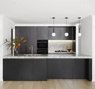 A kitchen with white walls and dark wood cabinets