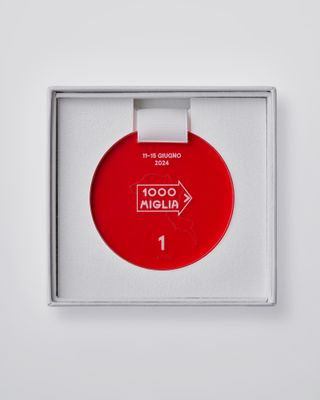 Medal for Mille Miglia 2024 as a red circular object created by Sabine Marcelis