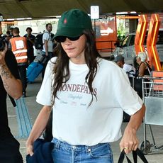 Bruna Marquezine and Shawn Mendes spotted at the S&atilde;o Paulo airport together. Marquezine is wearing a graphic T-shirt, green Polo hat, jeans, and red sneakers. She's carrying a dog carrier. 