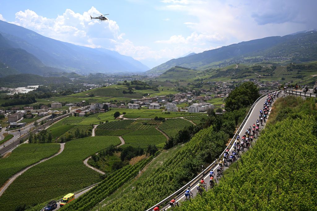 LEUKERBAD SWITZERLAND JUNE 14 A general view of the peloton passing through a vineyards landscape during the 86th Tour de Suisse 2023 Stage 4 a 1525km stage from Monthey to Leukerbad 1367m UCIWT on June 14 2023 in Leukerbad Switzerland Photo by Dario BelingheriGetty Images