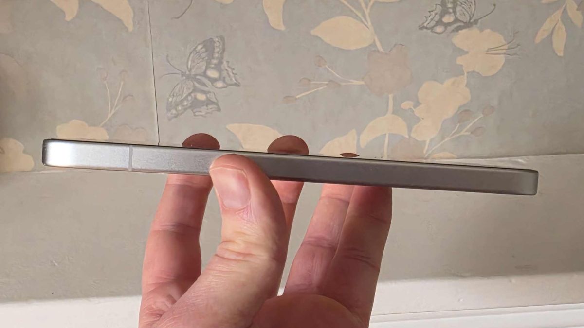 The Poco X8 Pro Max fron the side, while it's held in a man's hand.