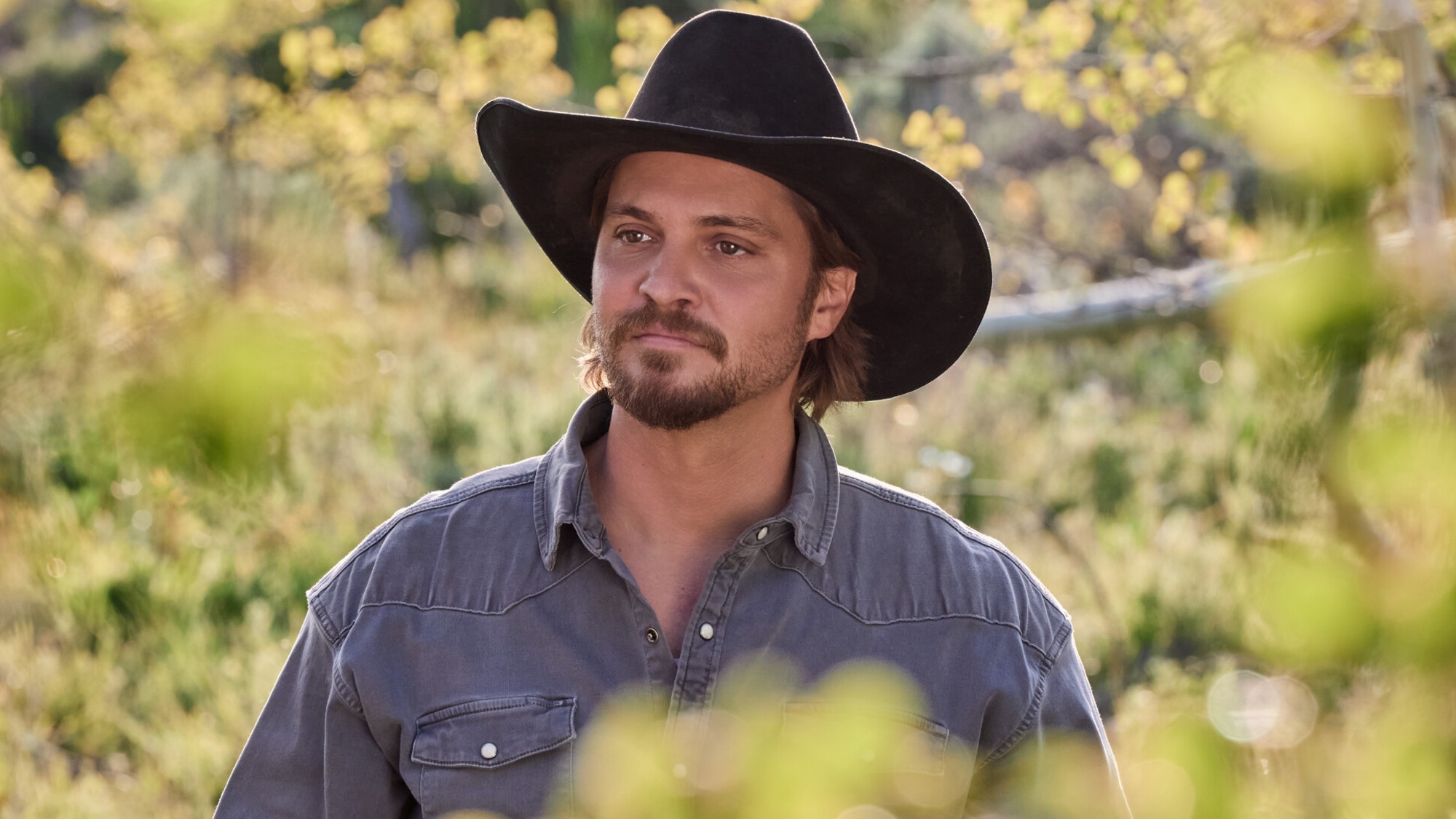 Luke Grimes standing and looking forward in Marshals.