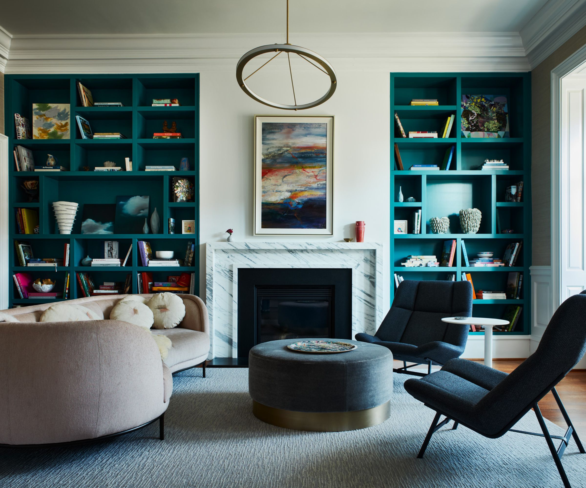 Living room with teal built-in shelving, white walls and modern decor.