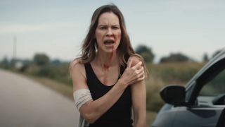 Screenshot of Hilary Swank's new character injured on the road outside her car in Yellowjackets Season 3