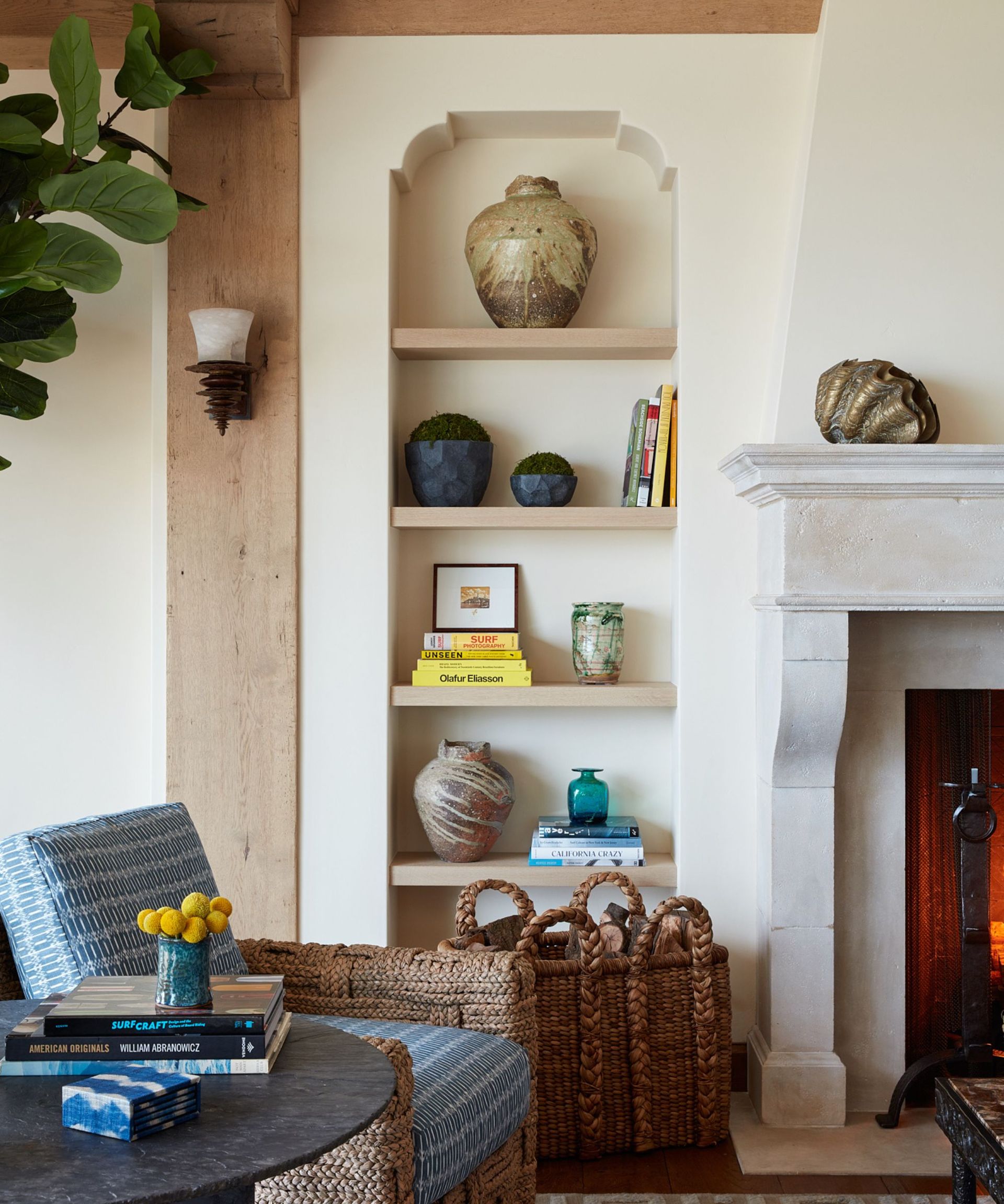 Transitional neutral living room with shelves with ornaments, rattan armchair and coffee table with books