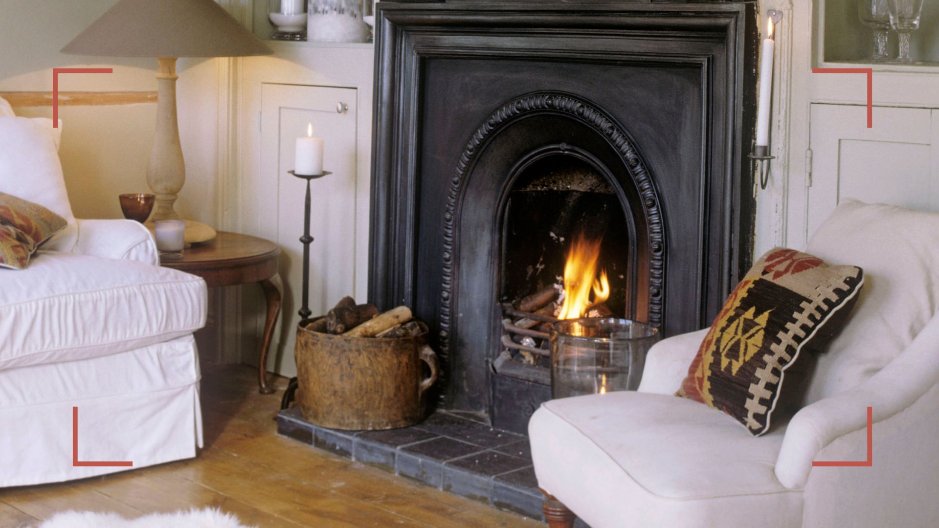 Cosy white living room with an open fire with a black cast iron fireplace to answer how often should you sweep your chimney