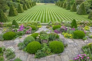 ROCKCLIFFE GARDEN, GLOUCESTERSHIRE: PATIO, TERRACE, STRIPED, STRIPES IN LAWN, BEECH OBELISKS, LA