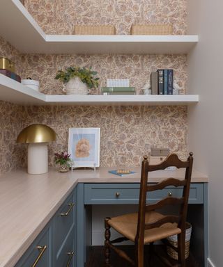 Corner home office space with open custom shelving, nature-inspired wallpaper, chair and hints of blue.