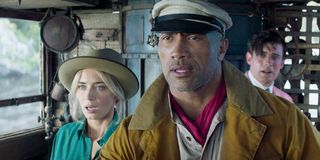 Dr. Lily Houghton (Emily Blunt), Frank Wolff (Dwayne Johnson) and MacGregor Houghton (Jake Whitehall) stand on a boat and look shocked in 'Jungle Cruise'