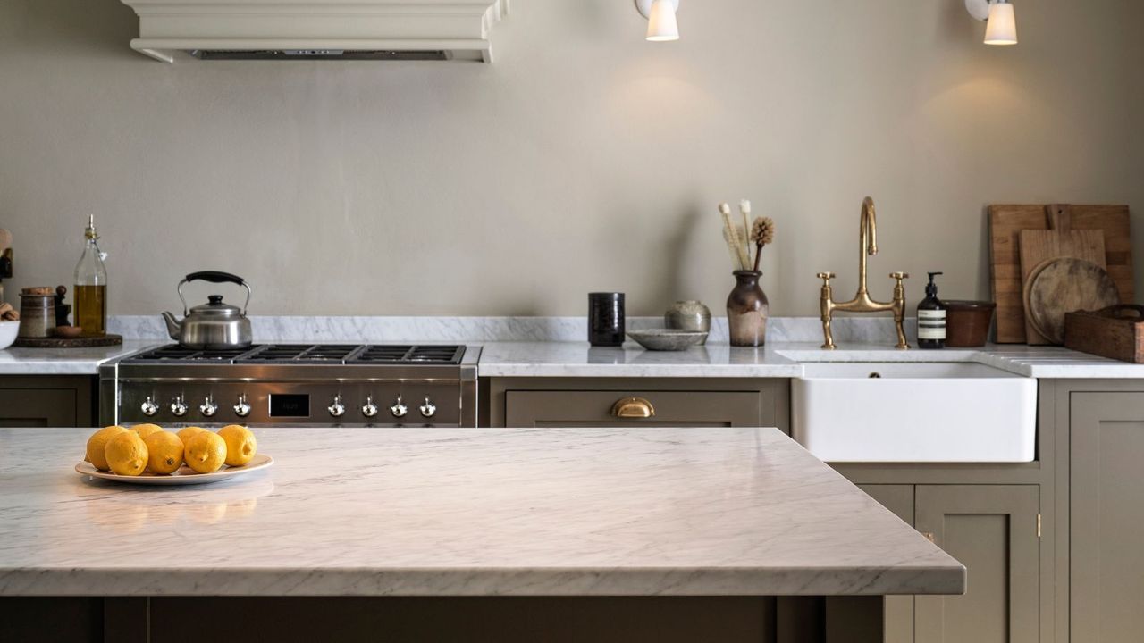 A kitchen with white countertops, white walls, and brown cabinets