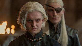Tom Glynn-Carney as Aegon II stands in front of Aemond (Ewan Mitchell) in House of the Dragon season 1