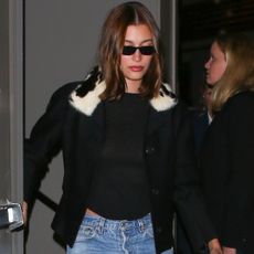 Hailey Bieber wore the cigarette jeans trend with a fur-trimmed jacket at a holiday party